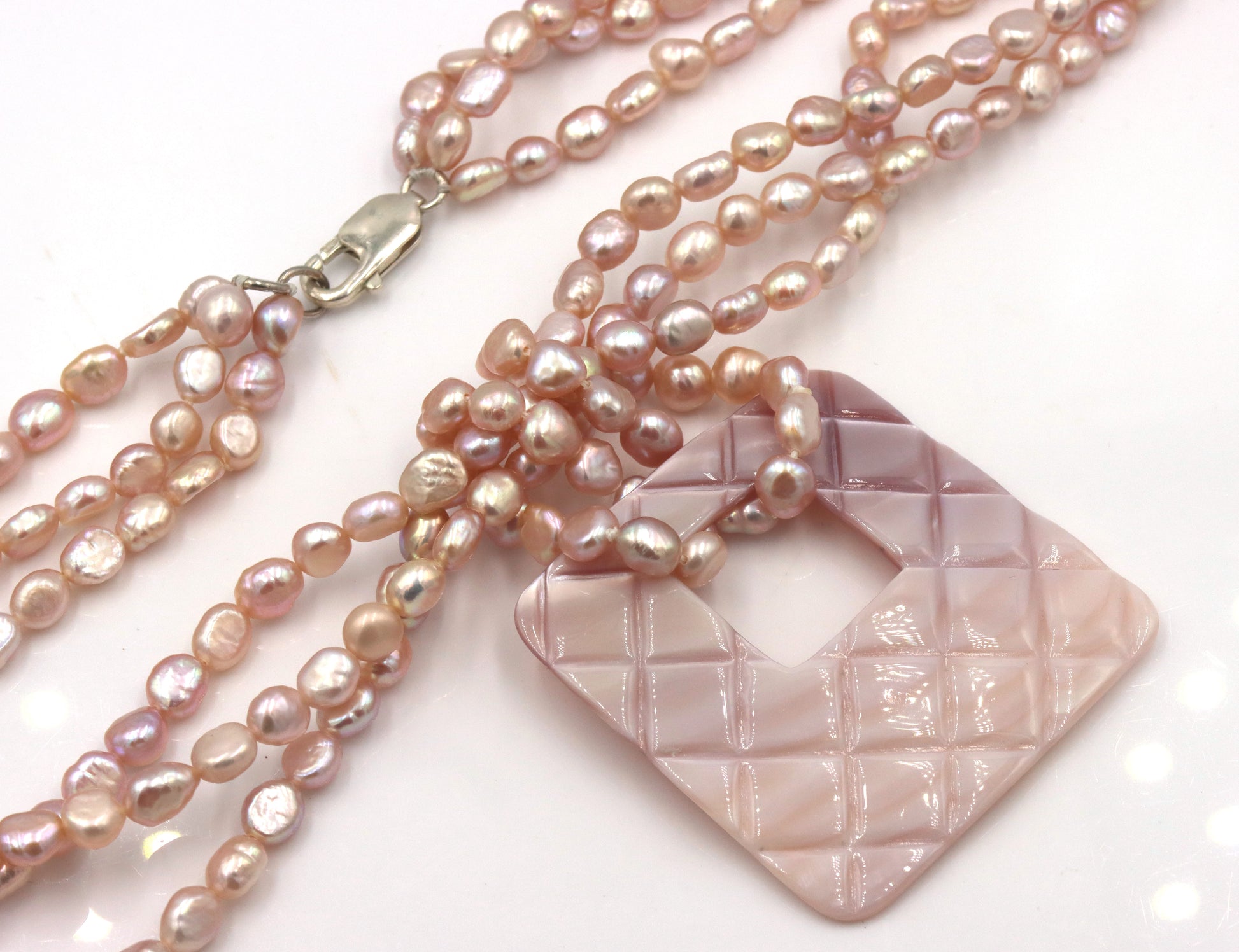 Pearl square pendant on multi strand pearl necklace